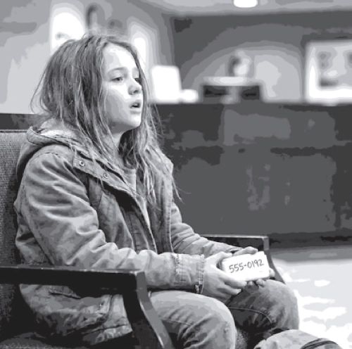 girl sitting in chair holding soap bar with hotline number